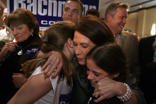 Michele Bachmann embraced Lexi, 11, and Cali Weddle, 9, of Andover. Bachmann’s husband, Marcus, is at right at the Bloomington Sheraton GOP gatherin