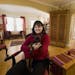 At home with her dog Edgrrr (3Rs), Angela McLaughlin likes the way the parlor, living room, and dining room, connected by archways, flows into one ano