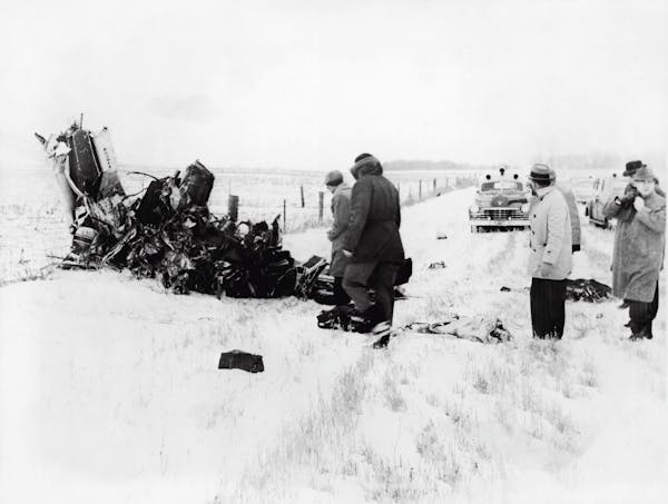 A group of men view of the wreckage of a Beechcraft Bonanza airplane in a snowy field outside of Clear Lake, Iowa, early February 1959. The crash, on 