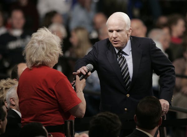 Republican presidential candidate Sen. John McCain, R-Ariz., right, takes back the microphone from Gayle Quinnell who said she read about Sen. Barack 