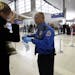 Transportation Security Administration agent Paul Marshall helps an international traveler at the Detroit Metropolitan Airport in Romulus, Mich. on Sa