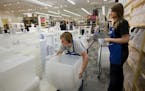 The Container Store manager, Chris Redding, and employee Anne Szczepaniak, re-stock storage containers. Forbes magazine has named the Container Store 