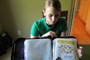 In this photo taken Tuesday, June 28, 2011, Monica Knight, a dental hygienist and mother of two, shows her coupon binder at her home in Boise, Idaho. 