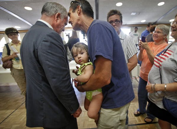 With his 13-month-old granddaughter Pieta in his arms, Leroy Dombrovski spoke to Gov. Mark Dayton in Rochester on Wednesday. Dayton was there to talk 