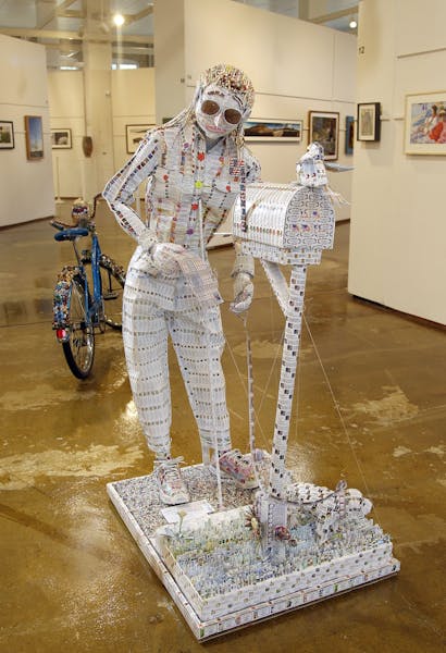 Made from return-address labels, Mary R. Zubrzyck's sculpture of a woman retrieving the mail won a first prize.