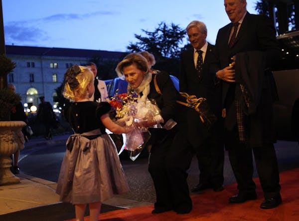 Norway's Queen Sonja greeted four-year-old Bergen Gandrud Pickett as she arrived with King Herald, right, at the St. Paul Hotel, Minn., Tuesday, Octob