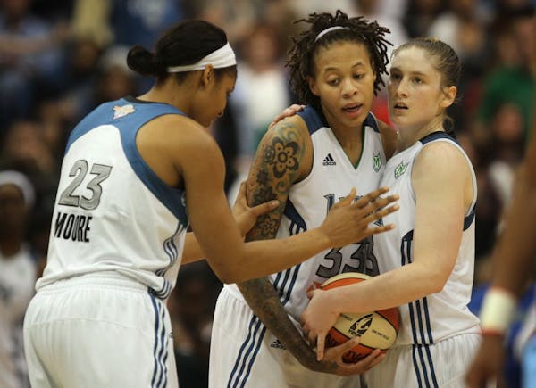 Seimone Augustus center was surrounded by teammates Maya Moore left and Lindsay Whalen late in the fourth quarter .