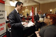 In this Oct. 4, 2011 photo, Blake Andrews with Verizon, left, visits with prospective employees during a job fair, in San Antonio. The United States a