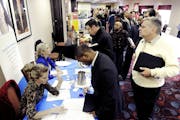 Job seekers attend the Minneapolis Career Fair held Wednesday, Nov. 2, 2011, in Bloomington, Minn. Fewer people applied for unemployment benefits last