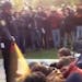 In this image made from video, a police officer uses pepper spray as he walks down a line of Occupy demonstrators sitting on the ground at the Univers
