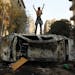 A protester stood atop a car burned during clashes with police in Cairo’s Tahrir Square. More than 20 people have been killed.