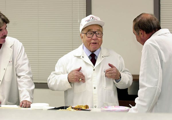 This Aug. 4, 2011, file photo, shows businessman and entrepreneur Jeno Paulucci, center, as he jokes during product testing at the research and develo