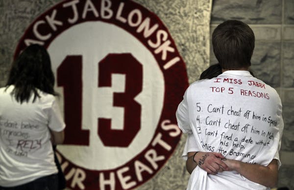 Two Benilde-St. Margaret's students hugged in the hallway Thursday in front of signs that students made.