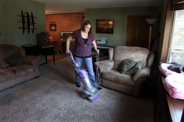 Laura Nielsen vacuumed her living room Tuesday, November 15, 2011. The second annual Working Mother study released last month revealed that both worki
