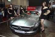 Models pose by Mercedes Benz SLS AMG Roadster on display during the 2012 Taipei International Auto Show at the Taipei World Trade Center in Taipei, Ta