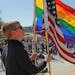 Blake Jacobson of St. Paul held a rainbow and an American flag on the steps of the State Capitol