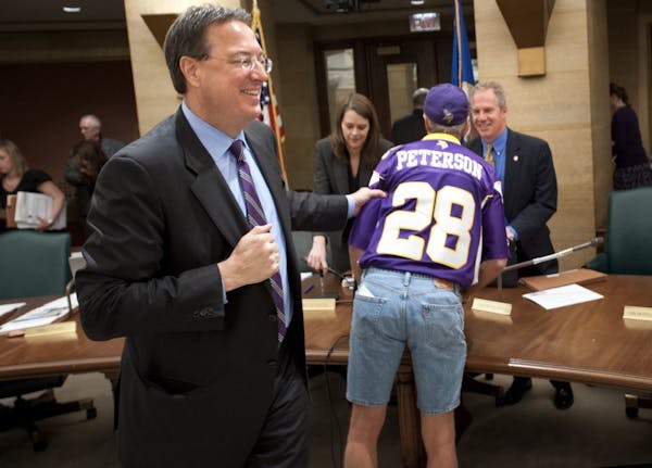 Vikings executive Lester Bagley grabbed “Superfan” Larry Spooner after the stadium bill was sent to the Senate Finance Committee.