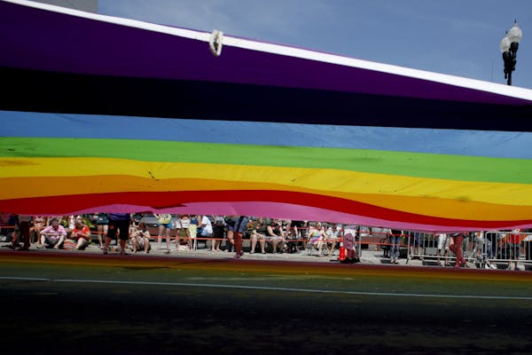 A vibrant rainbow parachute leads the way at the GLBT Pride Parade in Minneapolis, Minn. Sunday, June 24, 2012.
