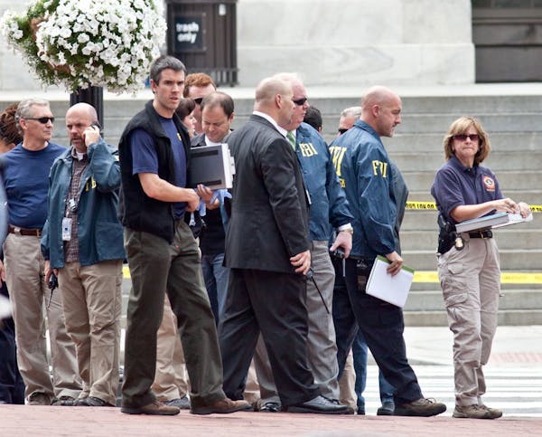 Washington Police and FBI agents gather outside the Family Research Council in Washington, Wednesday, Aug. 15, 2012, after security guard at the lobby