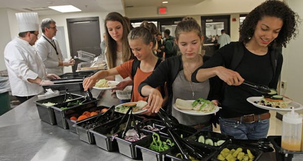 Washburn High School Chef Scott Prebish and School Lunch Director Bertrand Weber served custom-made sandwiches as students added their own toppings du