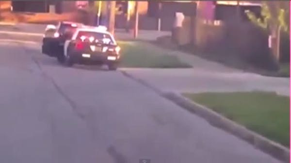 Woman who drove on sidewalk holds 'Idiot' sign