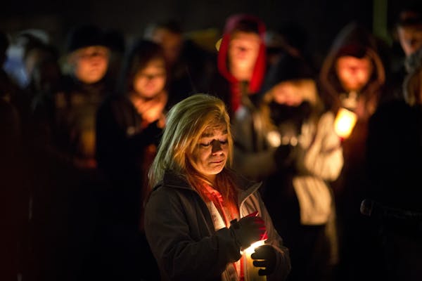 Rachel Brady, sister of Nick Brady, 17, and cousin of Haile Kifer, 18, shielded a candle during Sunday evening’s vigil in Little Falls.