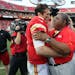 Kansas City Chiefs quarterback Brady Quinn, left, is hugged by head coach Romeo Crennel at the end of an NFL football game at Arrowhead Stadium in Kan
