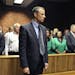 Olympian Oscar Pistorius stands following his bail hearing in Pretoria, South Africa, Tuesday, Feb. 19, 2013. Pistorius fired into the door of a small