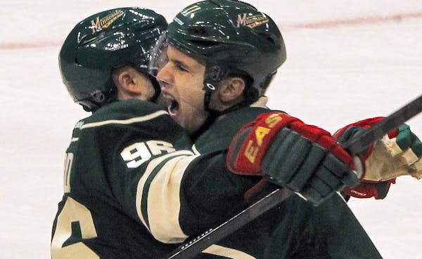 Pierre-Marc Bouchard (96) cclebrated with Zach Parise, right, after Parise scored his first goal of the season on Sunday.