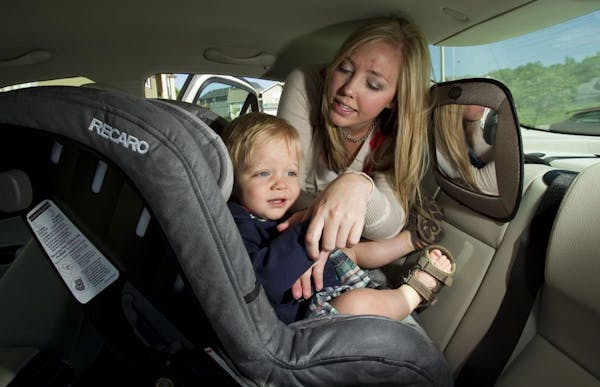 Sarah McIntosh, of Kansas City, North, buckles Ethan McIntosh, 13 months, into his car seat as they sat in their driveway, May 26, 2011, in Kansas Cit