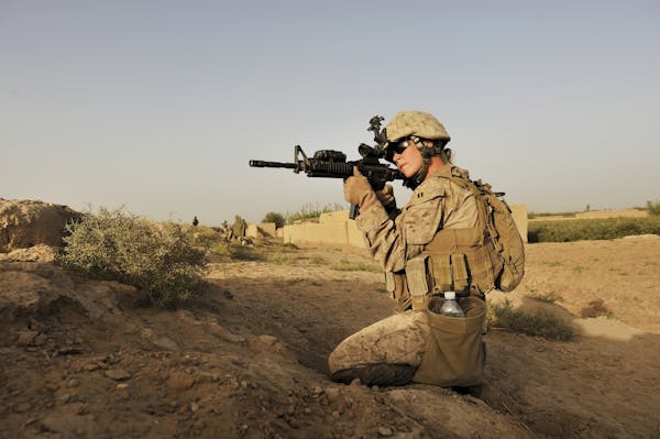 U.S. Marine Capt. Emily Naslund, who is part of a group of female Marines tasked with interacting with Afghan women, aims her weapon after shots were 