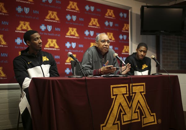 Flanked by Austin Hollins, left, and Rodney Williams, Jr., right, Head Coach Tubby Smith answered a question during the news conference. The Universit
