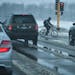 A lone bicyclist braved the early spring snow and slush Thursday morning crossing Highway 110 along Dodd Road in Mendota Heights. Thursday, April 11, 