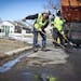 Josh Mallinger shoveled hot asphalt mix over potholes with other city workers last week on a Burnsville residential street.