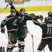Andrew Brunette, Jim Dowd and Pascal Dupuis of the Wild celebrate Brunette's goal in the third period clinching the team's first-ever postseason win i