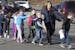In this photo provided by the Newtown Bee, Connecticut State Police lead children from the Sandy Hook Elementary School in Newtown, Conn., following a
