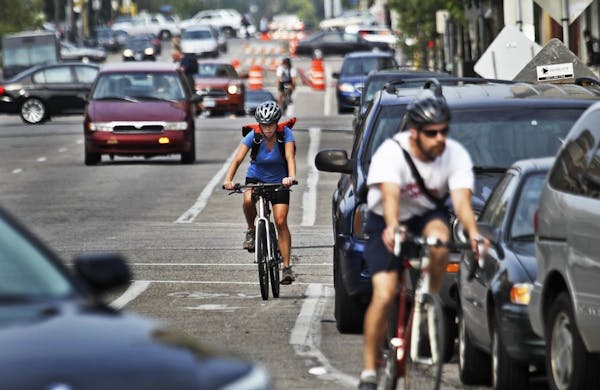 Bicyclists and cars co-exist while heading south in heavy traffic along Portland Ave., near E. Grant Street Thursday, Aug. 30, 2012, in Minneapolis.