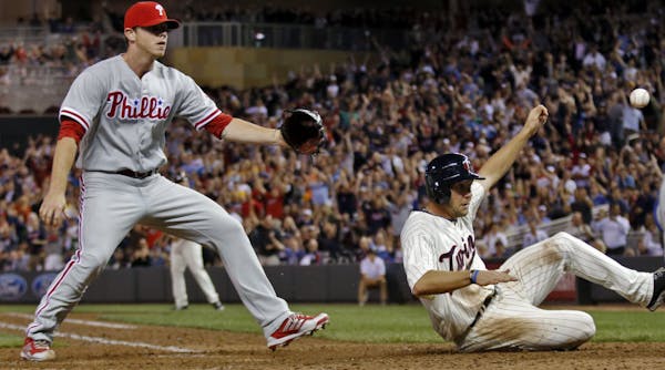 Clete Thomas slid safely into home on a wild pitch beating the relay throw to Phillies pitcher Justin DeFratus to score the game-winning run in the ei