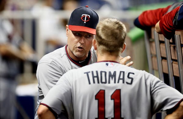 Minnesota Twins hitting coach Tom Brunansky talks to Clete Thomas (11) in the dugout during the eighth inning of a baseball game in Miami.