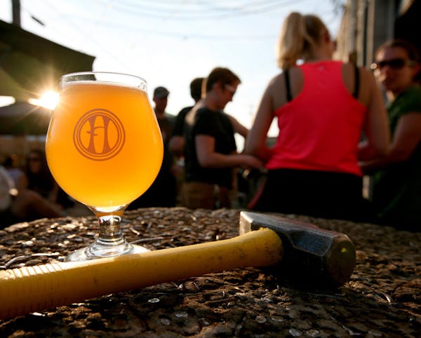 A glass of Saison Nourrice, traditionally brewed for farmhands during hot summer months, sits on a Hammerschlagen stump that doubles as a patio table 