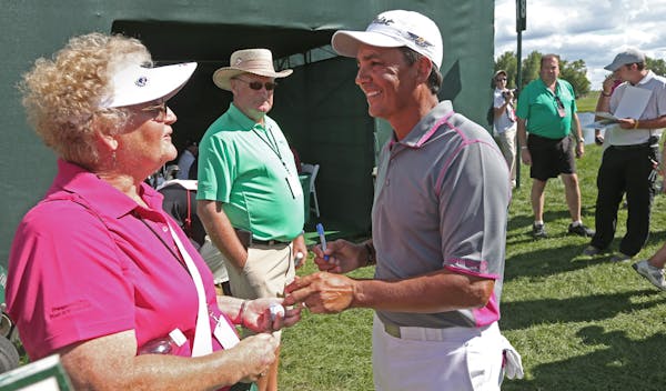 Volunteer Sally Altman of Mora, Minn., smiled after getting an autographed golf ball from Tom Pernice Jr. after he finished the second round of the 3M
