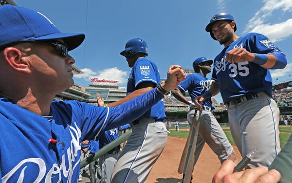 Kansas City coach Pedro Grifol celebrated with Justin Maxwell and Eric Hosmer after they scored in the sixth inning against the Twins.