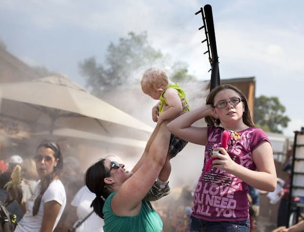 Sarah Roy of Maplewood holds up her 1-year-old son, Mikey Roy, to the misters on a hot day at the Minnesota State Fair August 24, 2013.