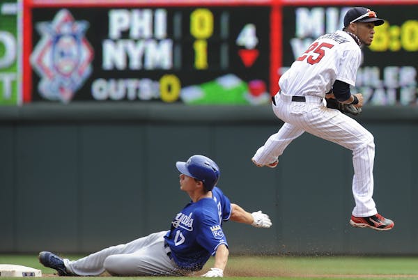 Twins shortstop Pedro Florimon jumped to avoid the slide of the Royals’ Chris Getz.