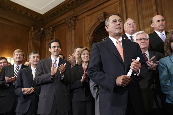 Speaker of the House John Boehner, R-Ohio, right, is cheered as Republican members of the House of Representatives rally after passing a bill that wou