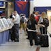 In this Friday, Sept. 27, 2013 photo, Delta Air Lines passengers line up to check luggage at Hartsfield-Jackson Atlanta International Airport, in Atla