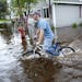 Brytton George rode his bicycle through the flooded streets a few blocks from his home in Carlton, Minnesota, about 20 miles south of Duluth, Minnesot