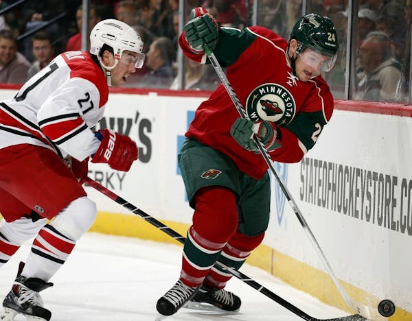 Justin Faulk (27) and Matt Cooke (24) battled for the puck behind the net in the first period.