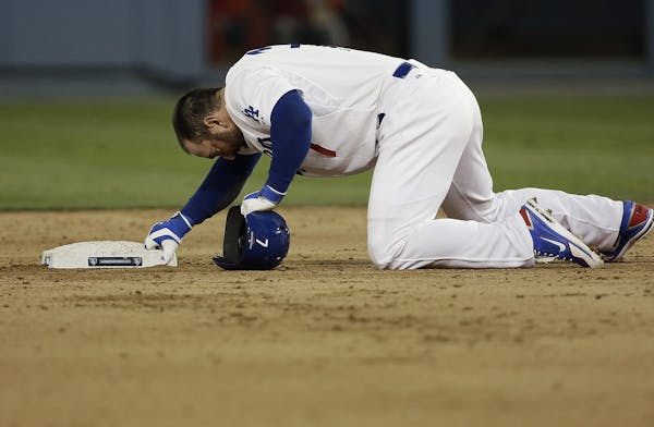 Los Angeles Dodgers' Nick Punto prepares to get up after being picked off second during the seventh inning of Game 4 of the National League baseball c