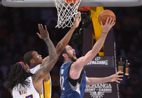Wolves forward Kevin Love, right, put up a shot against the Lakers' Jordan Hill, left, and Wesley Johnson.